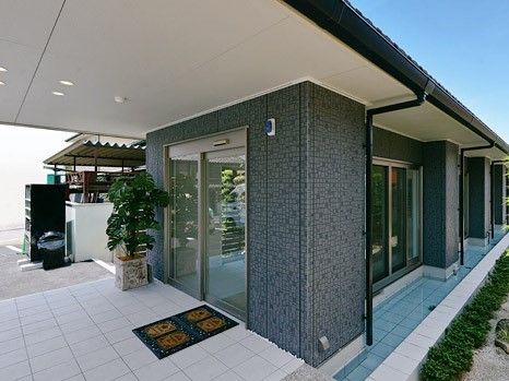 エントランスがガラスの自動ドアとなっていて、大きな鉢植えの木が置かれている。