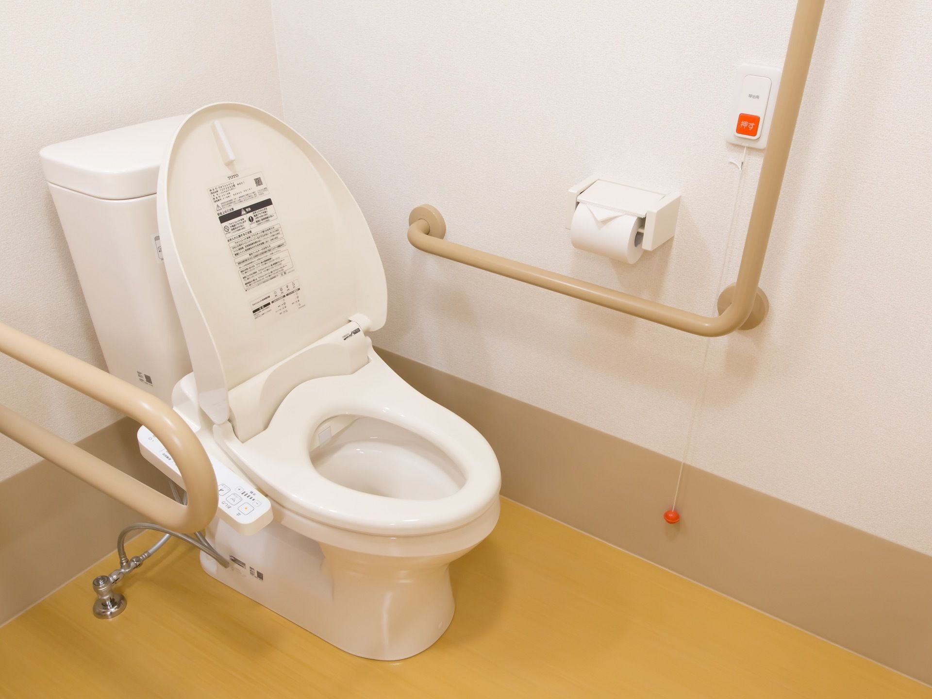 トイレは壁の両側に手すりが取りつけられている。手の届く位置に緊急用のボタンも設置されて、安全に使用できる。