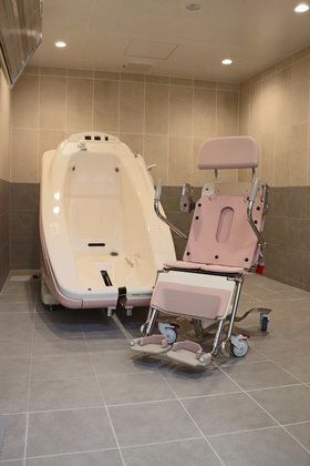 機械浴が完備され、介護度が高い人にも対応しているタイル張りの浴室。やわらかな雰囲気の照明を使っている。