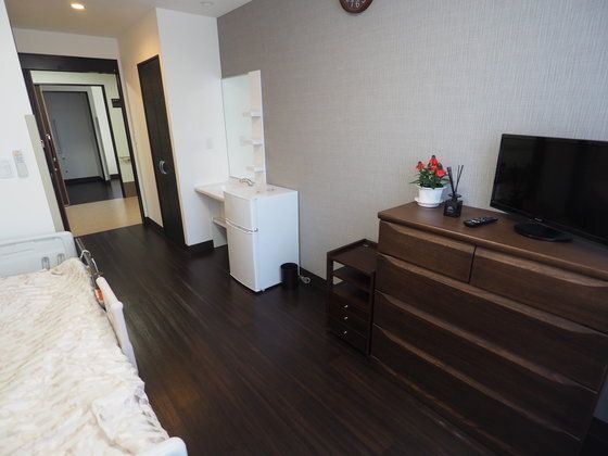 洗面所付きの居室には、チェストやテレビ、ベッド、冷蔵庫などの家具家電もそろっている。
