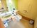 洗面台が完備された、洋式のトイレである。壁に手すりやナースコールが設置されている。上下に動く、可動式の手すりもある。