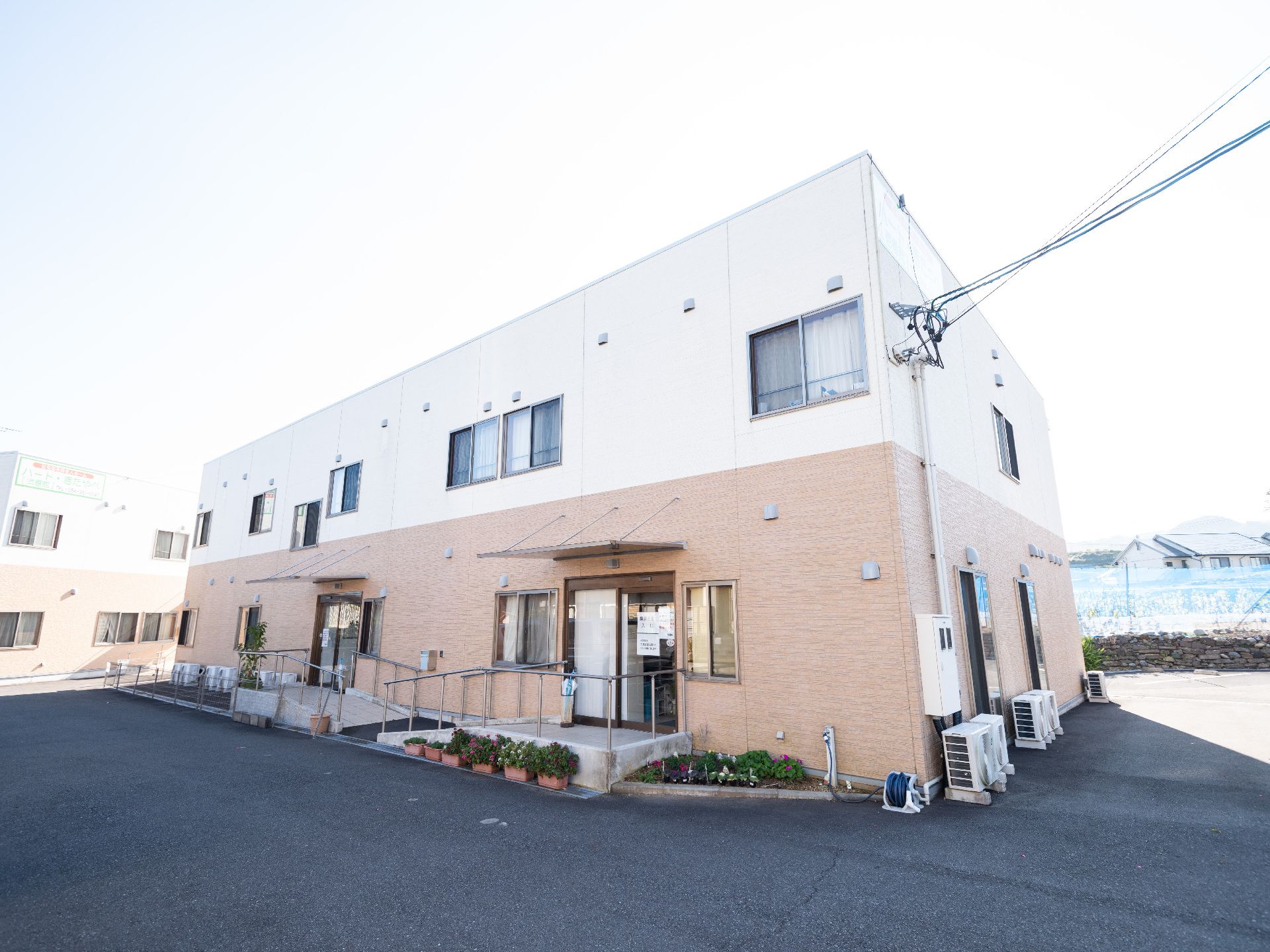 両端に手すりがある緩やかなスロープを入り口に設置している建物