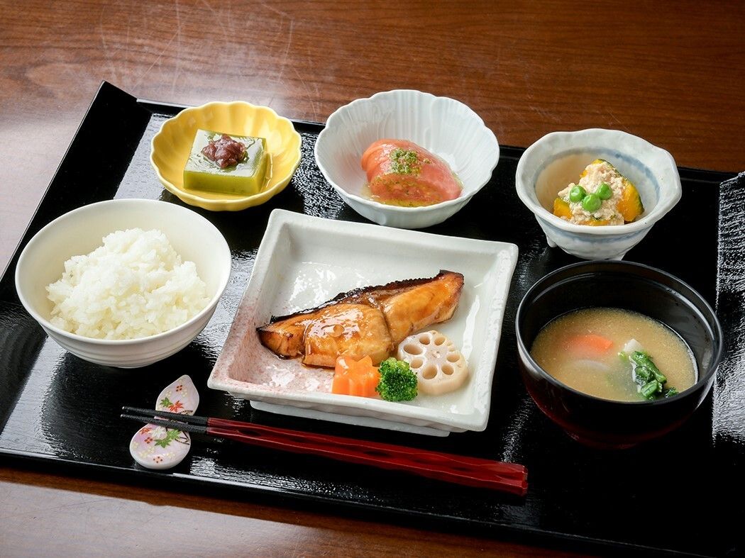 メインの焼き魚とそのほか小鉢が３種類彩りよくお盆に置かれている。白米と汁物もついたバランスの取れた食事