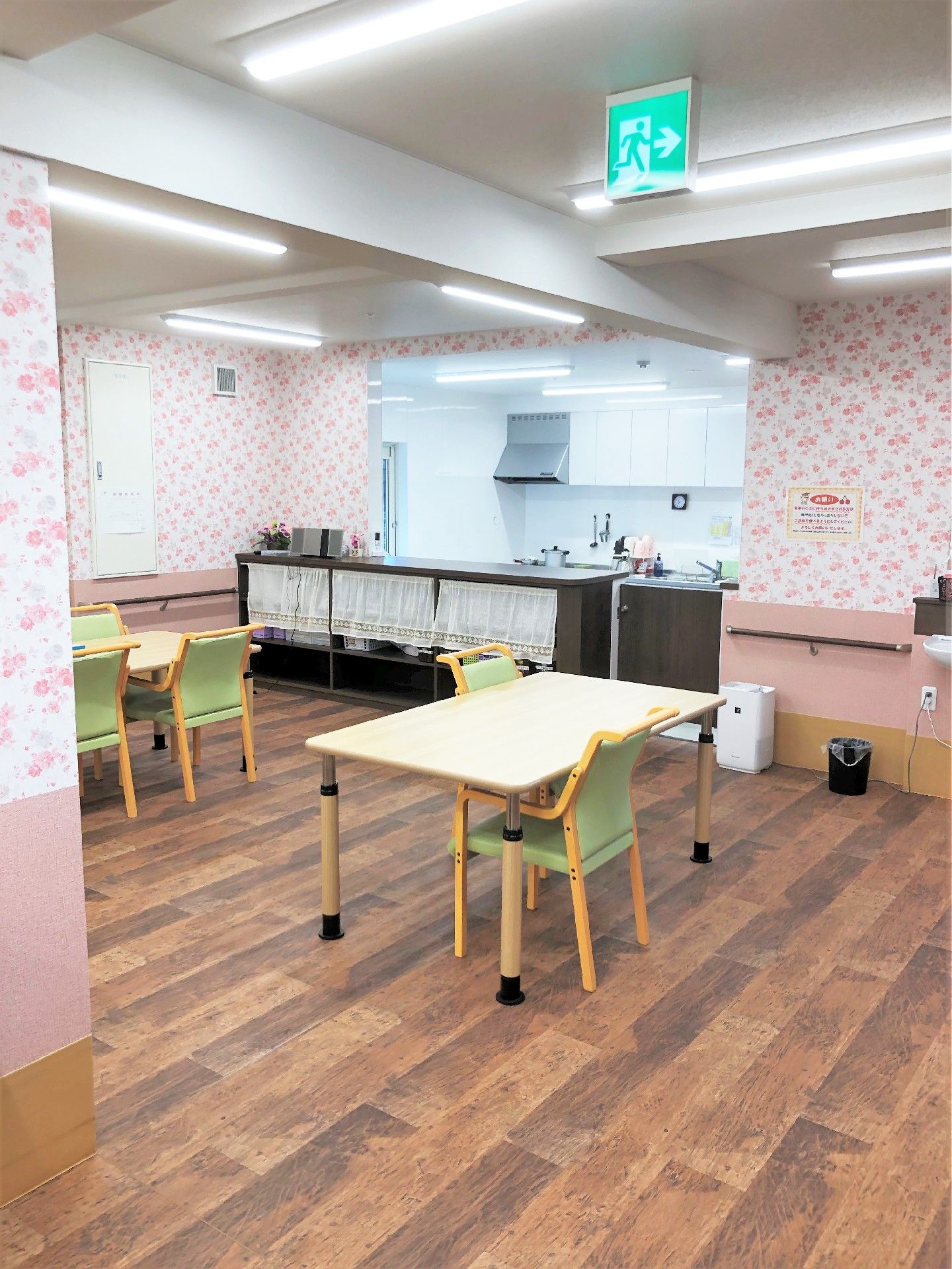 ピンク色の花柄の壁の部屋。フローリングの木目がとてもシックな感じになっている。