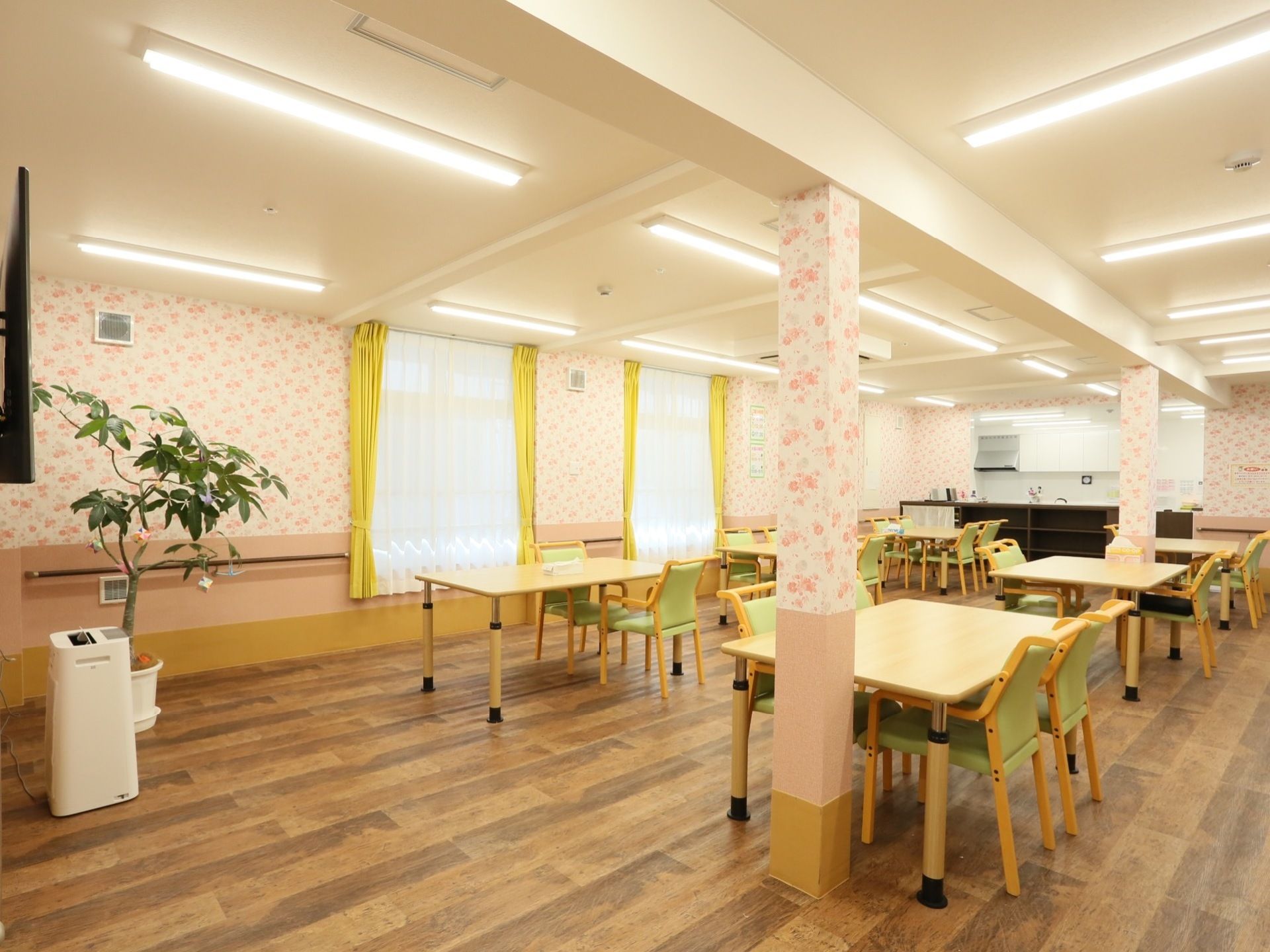 奥に窓が2つ設置されている。その手前には食卓と椅子がセットで均等に並べられている。右奥に見えるキッチンから近い位置にあり、配膳しやすい。