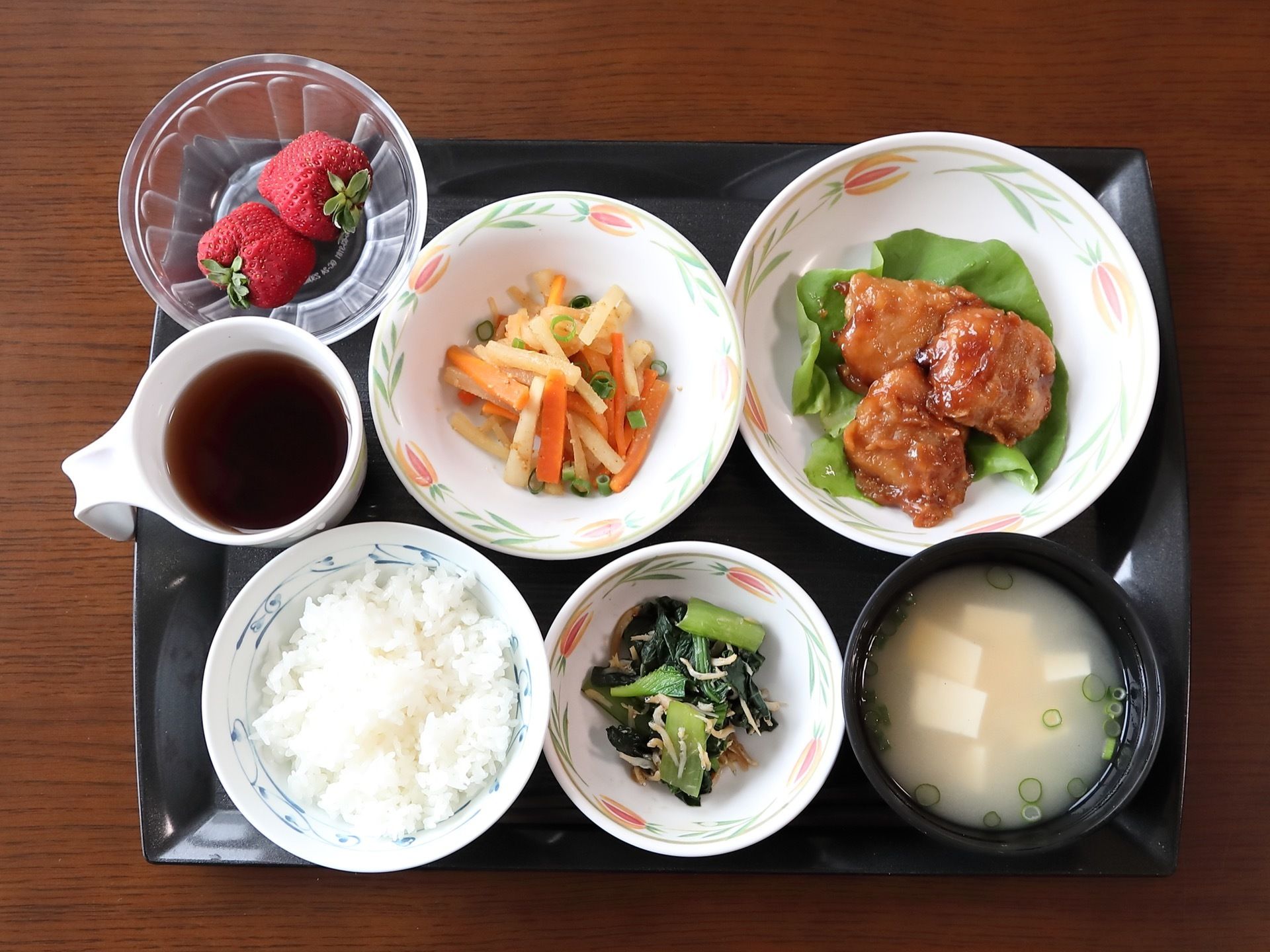 テーブルの上に置かれた黒いトレイには、栄養バランスと彩を考えて作られた美味しそうな食事が用意されている。