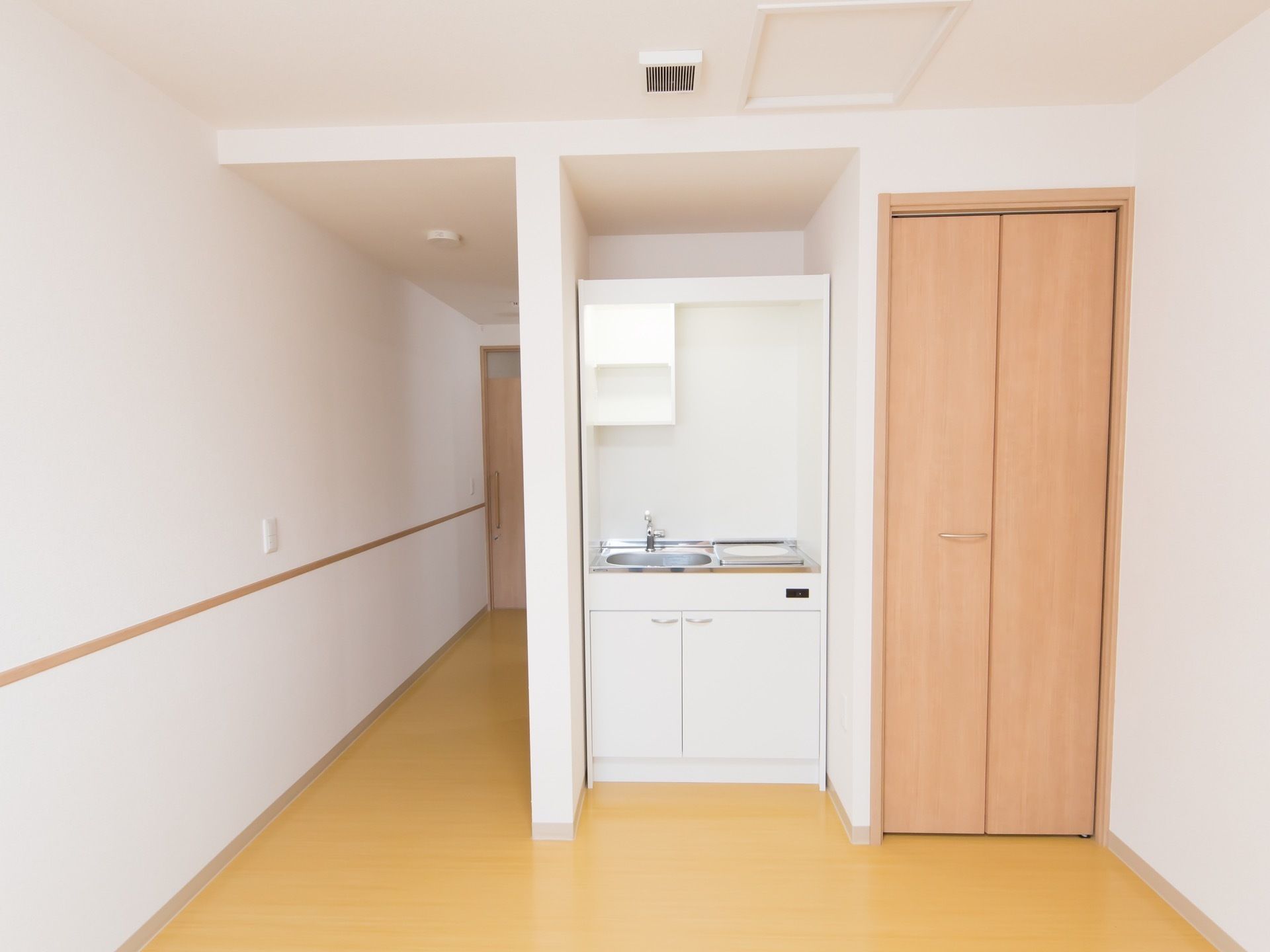 部屋の出入り口から長い通路が伸びており、部屋の奥が広くなっている。部屋の一角に流し台がはめ込まれており、右側にクローゼットがある。