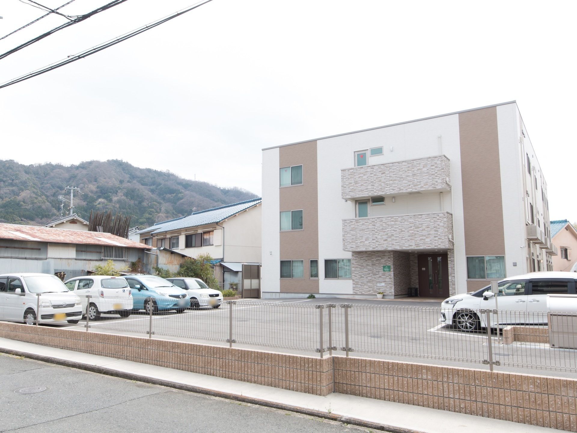 シックな色合いの建物の写真。日当たりの良い晴れた日に移された施設の外観
