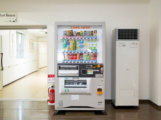 大きな自動販売機が置かれていて、ホットドリンクとコールドドリンクが売られている。左側には廊下が続いている。