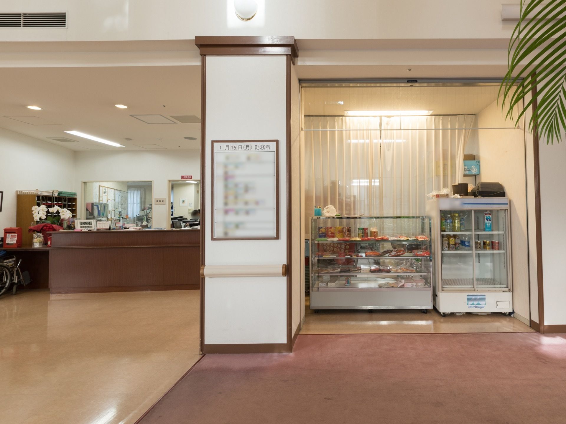 左手には受付があり、中央の柱にはスタッフの勤務表が張られている。右手の売店には飲料や菓子類を販売している。