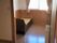 ベッドが置いてあるシンプルなワンルームタイプの部屋。手前にトイレがある様子