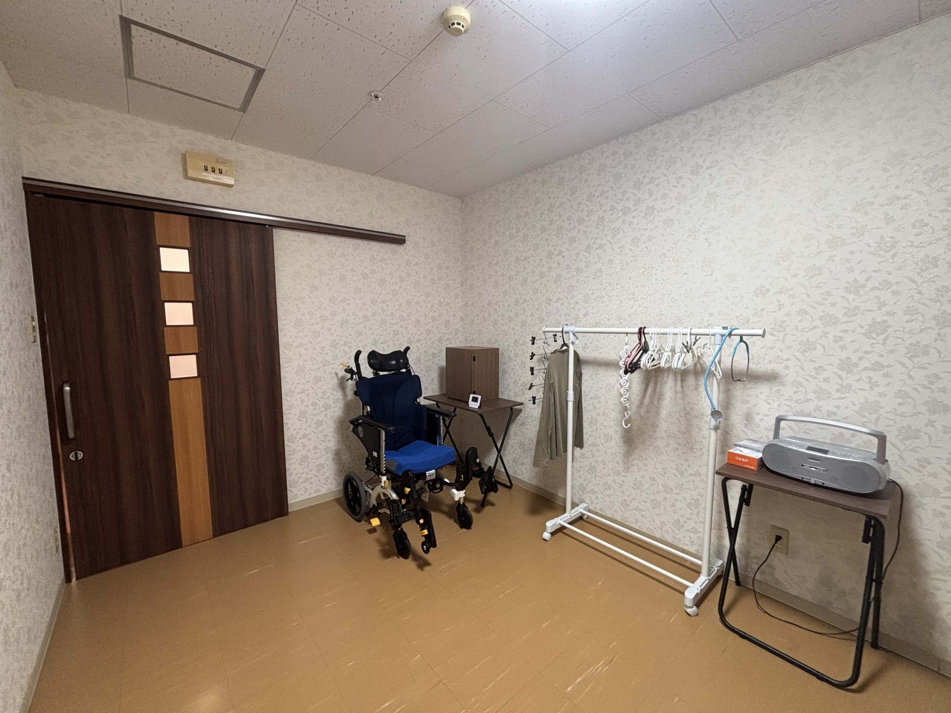 車椅子とハンガーラックの部屋