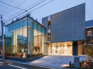夕暮れ時にライトアップされた建物。左側にはガラス張りの広いスペースがある。