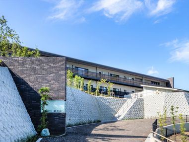 横に長い建物の外観写真。広めの中庭のような場所に建物が建っている
