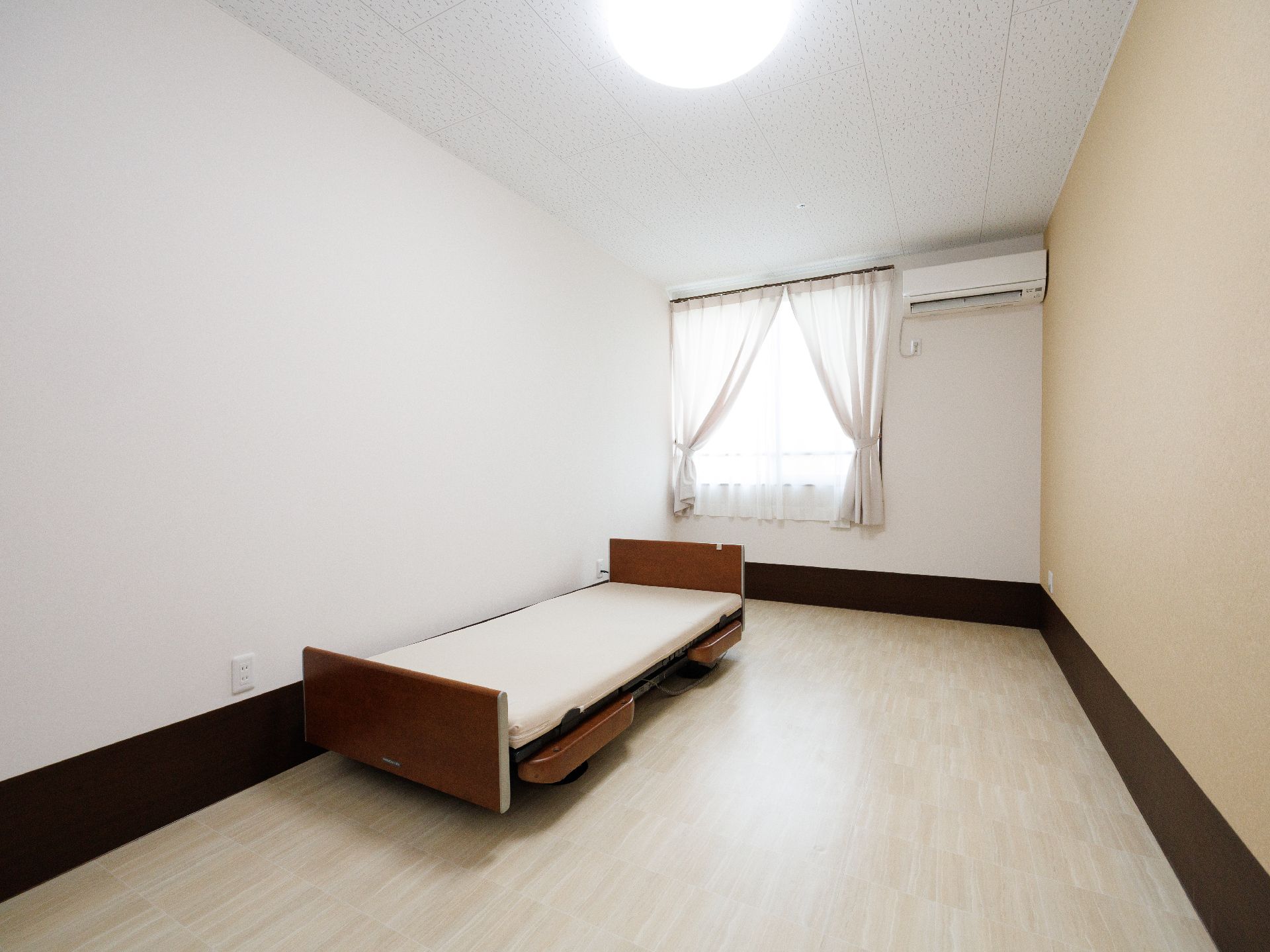 ベッドの置かれた白い壁の部屋