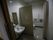 手洗い場が設けられたトイレである。仕切り扉が設置され、便座の横の壁には手すりや緊急呼び出しブザーが付けられている
