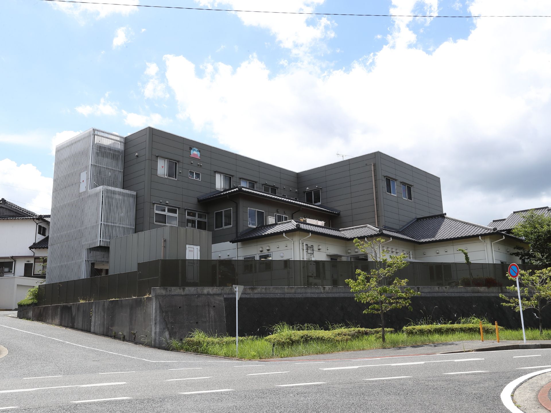 アスファルトに隣接したグレーの外観の建物