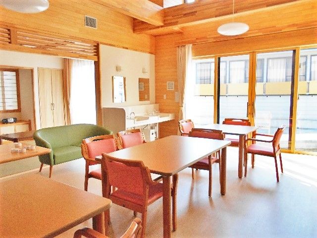 木目調を生かしたデザインが家庭的な館内。ダイニングテーブルが複数置かれている。