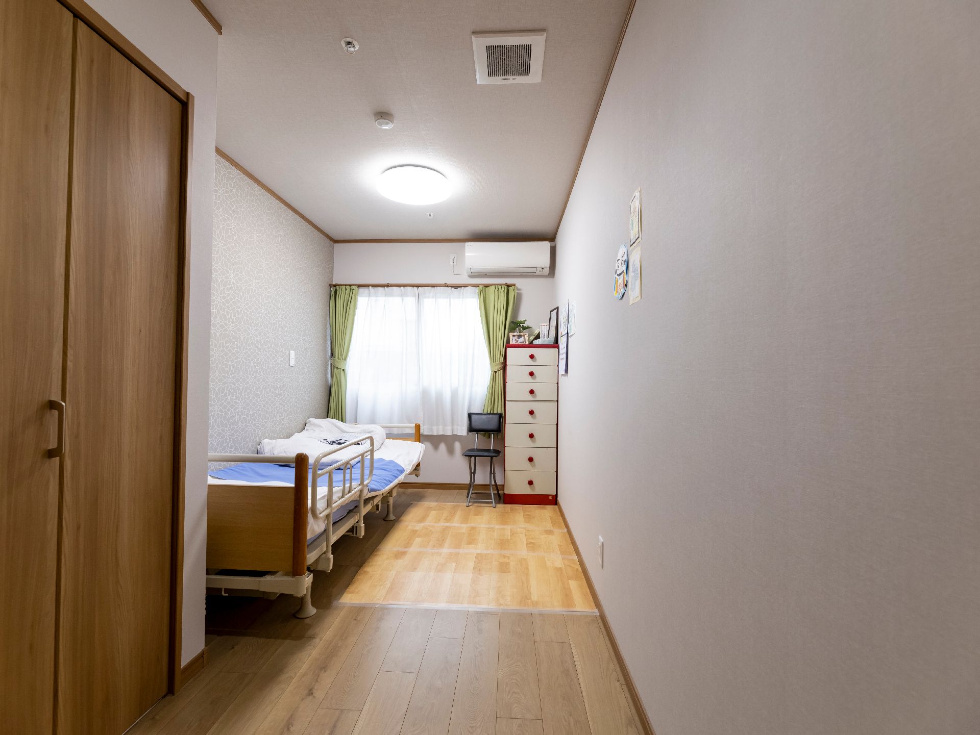 窓から日差しが差し込み、介護ベッドが置かれている居室