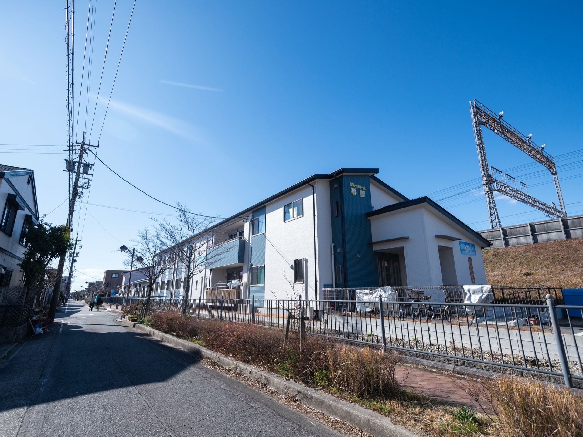 青空を背景に立地している2階建て施設である。外壁はコバルトブルーと白を配色に取り入れ、設計されている。