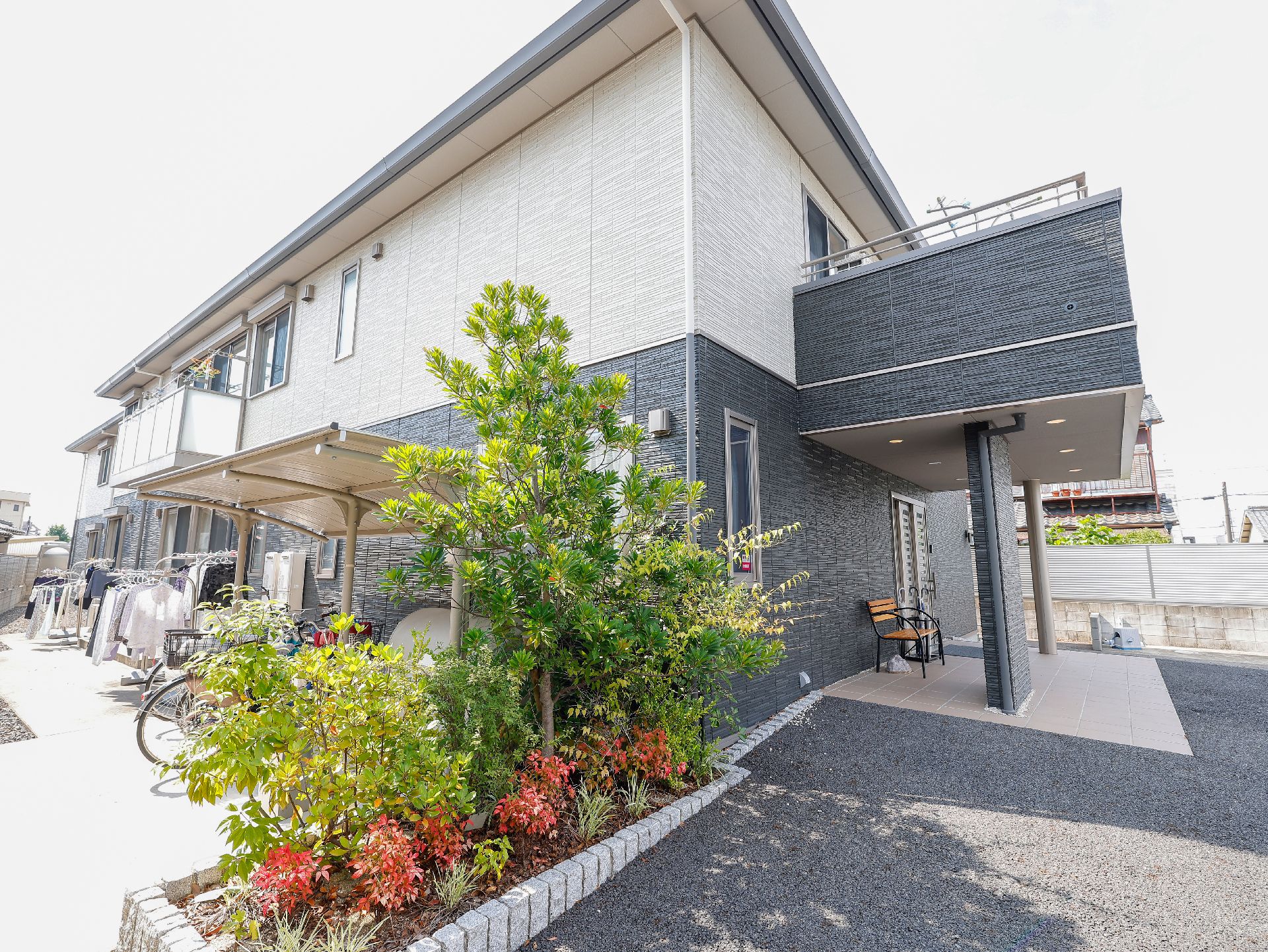 入居者・スタッフが世話をしている、木々や赤い花が植えられている花壇