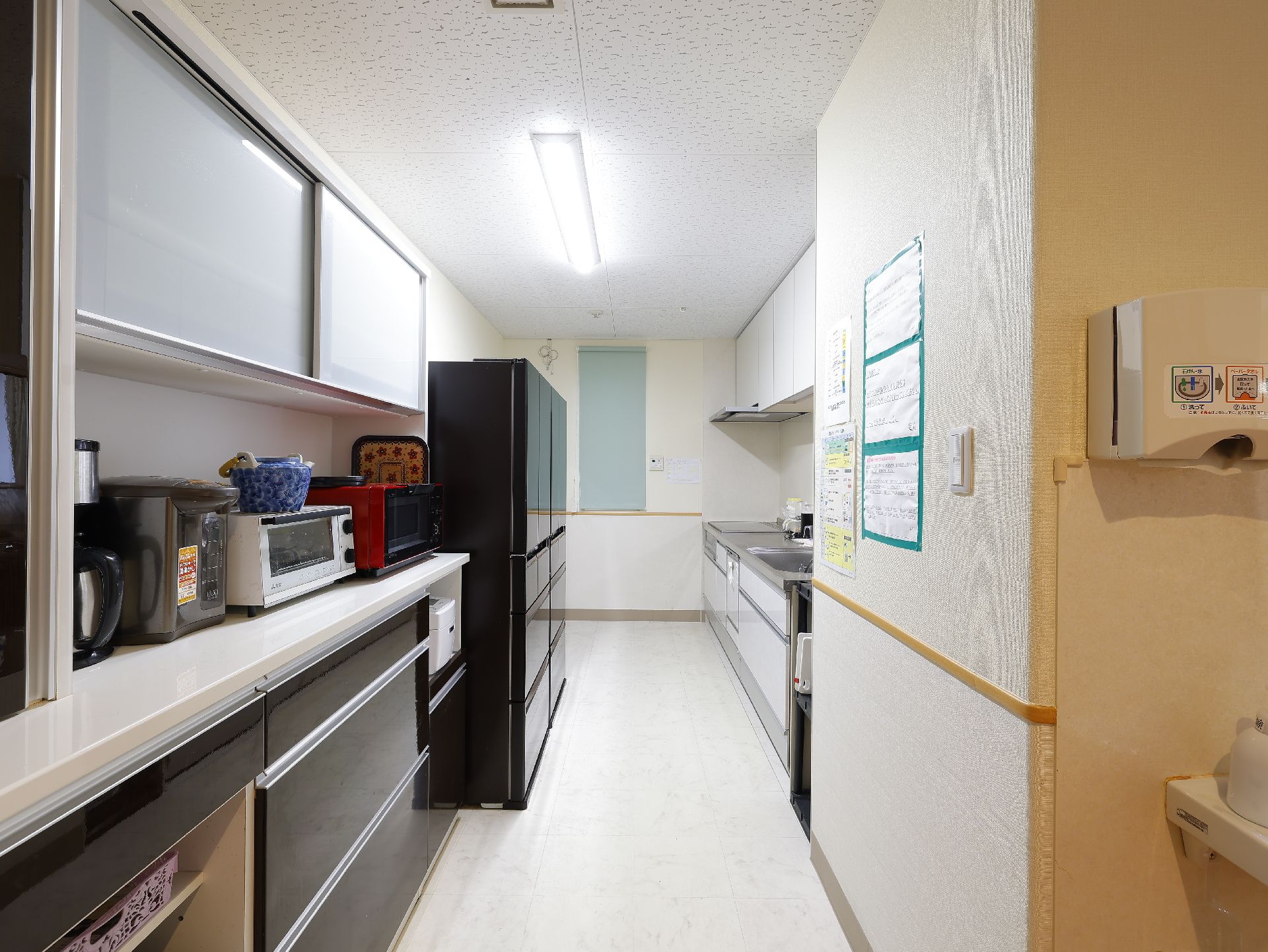 冷蔵庫、電子レンジ、オーブンなどが置かれているキッチン