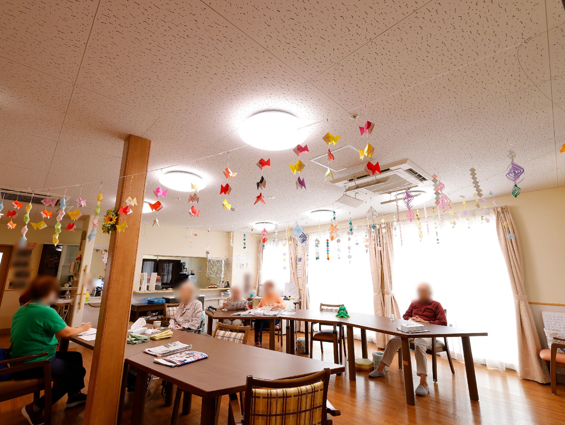 大きなガラス戸があり、カラフルな飾りで装飾されているリビング