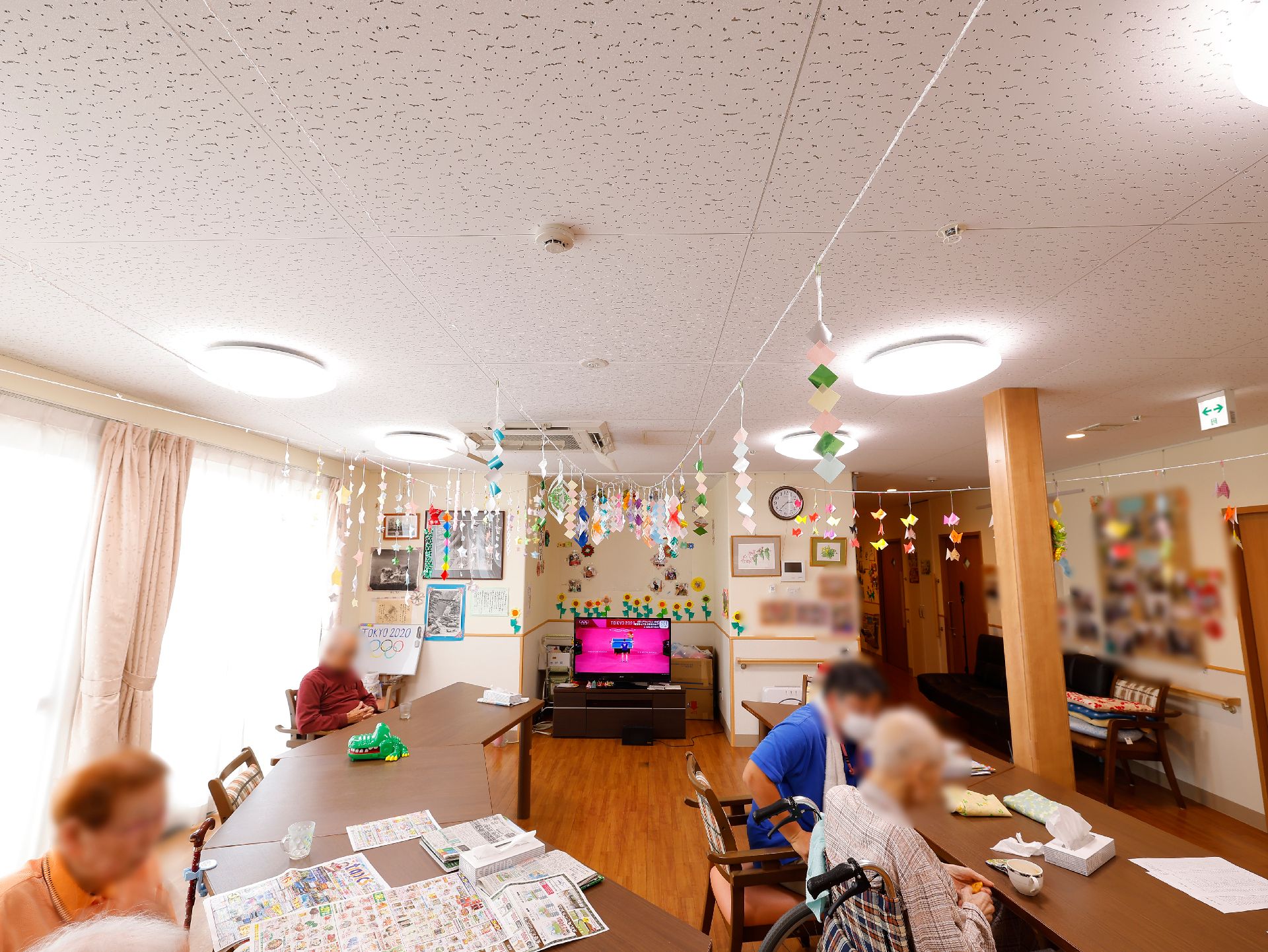 テーブルが並べられ、壁に飾りがたくさん取り付けられているリビング