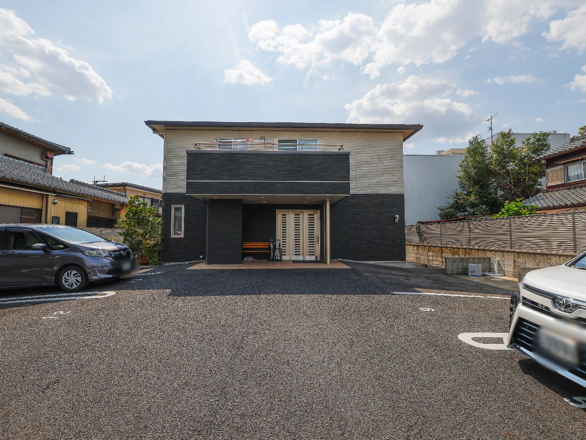 2階部分がホワイト、1階部分がグレーで、対比的な色合いが特徴の外観