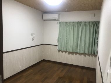 シンプルなフローリングの居室は窓が大きく、緑のカーテンが設置されている。