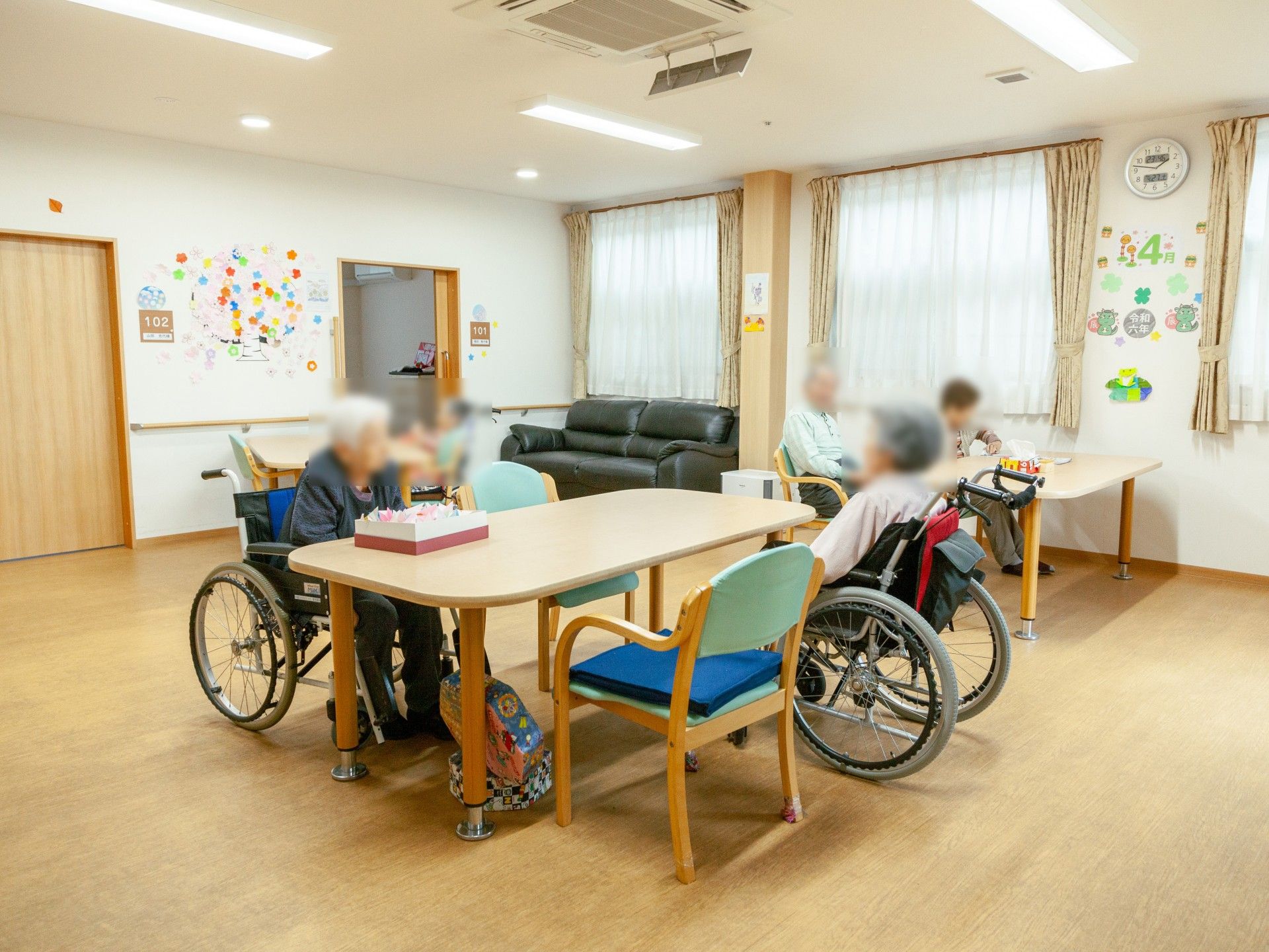 車椅子に座っている高齢女性と向き合う女性ヘルパー