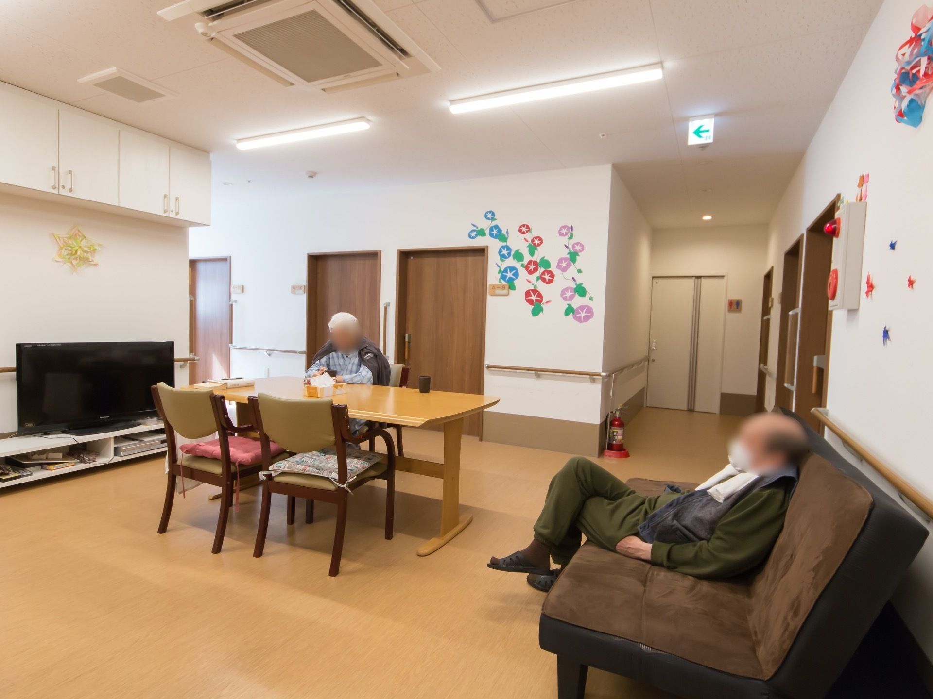 壁には手作りの小物が飾られている。テレビ、ソファとテーブルセットが置かれ、入居者様が寛ぐことができる。