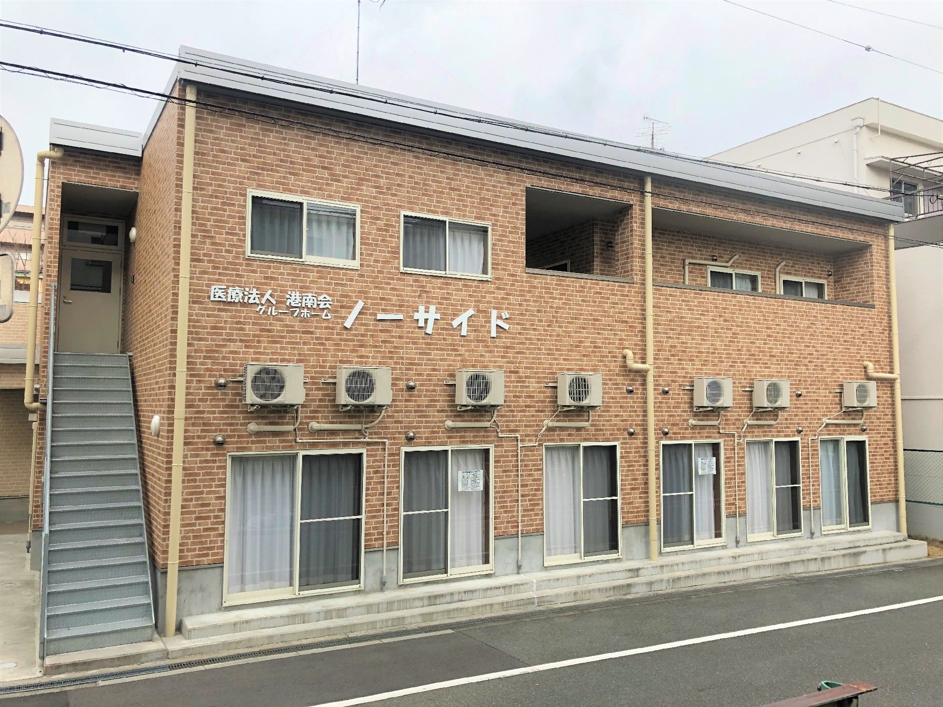 施設外観。レンガ調の外壁に大きく施設名が付いている。