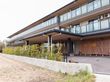 幅広い外観で、植栽を設けた３階建ての施設である。各居室にはエアコンやベランダが完備され、見通しの良いフェンスが設置されている。