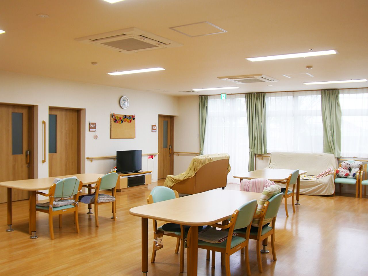 紙を貼るレクリエーションを楽しむ高齢女性と女性スタッフ