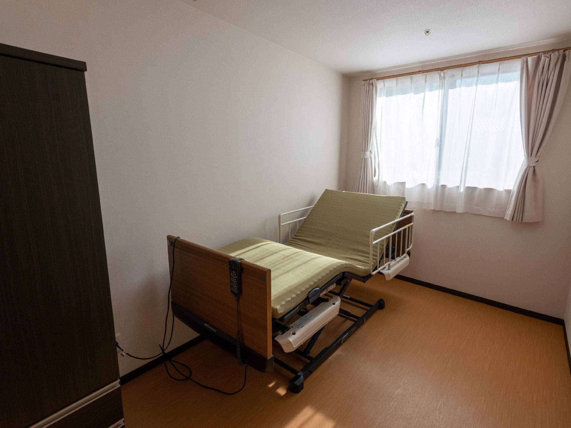 介護ベッドや収納棚、テーブルが設置されている居室