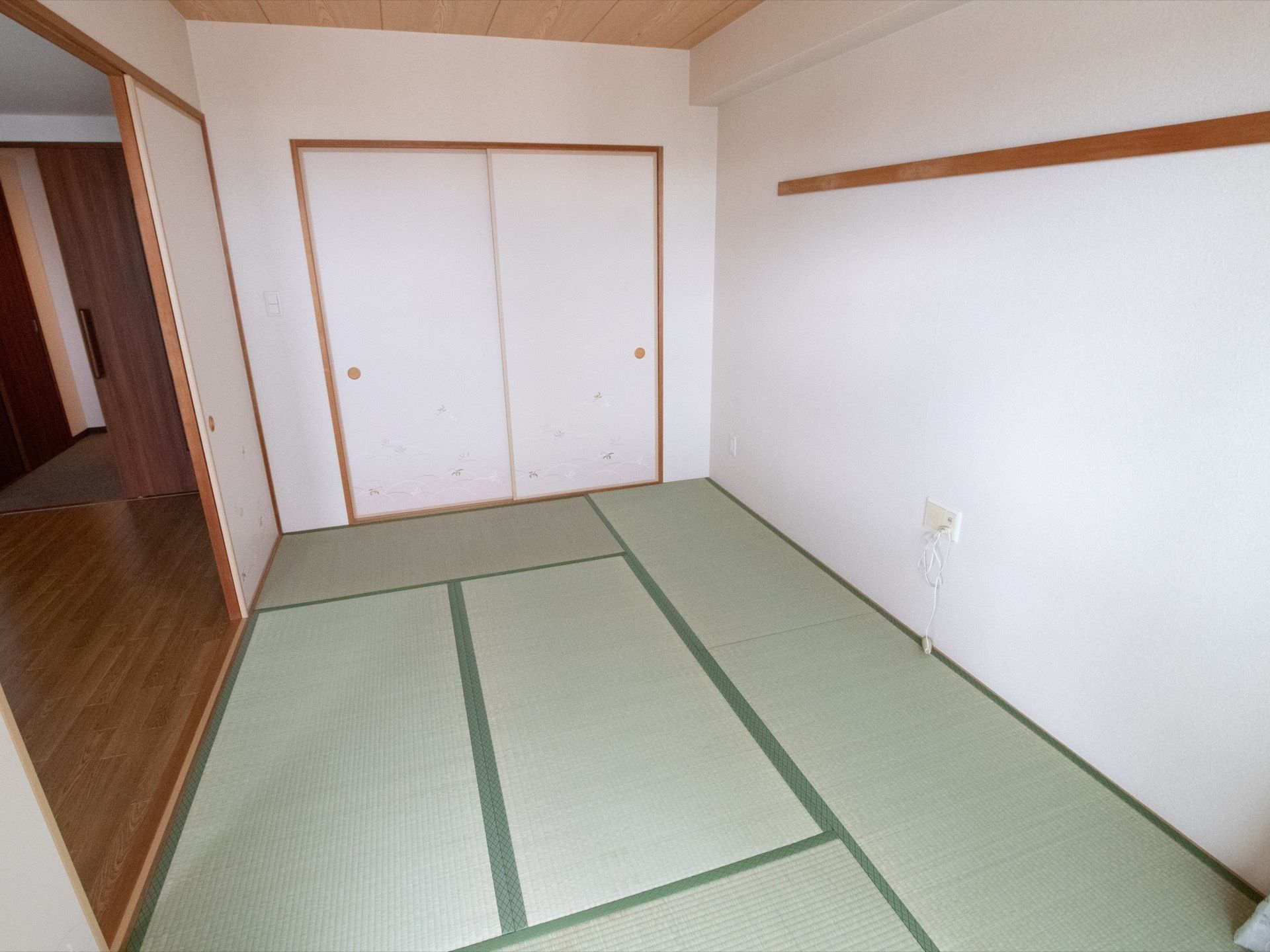 居室内には六畳敷きの和室がある。白と明るいブラウンを基調とした内装で、壁には収納用の押し入れを設置している。