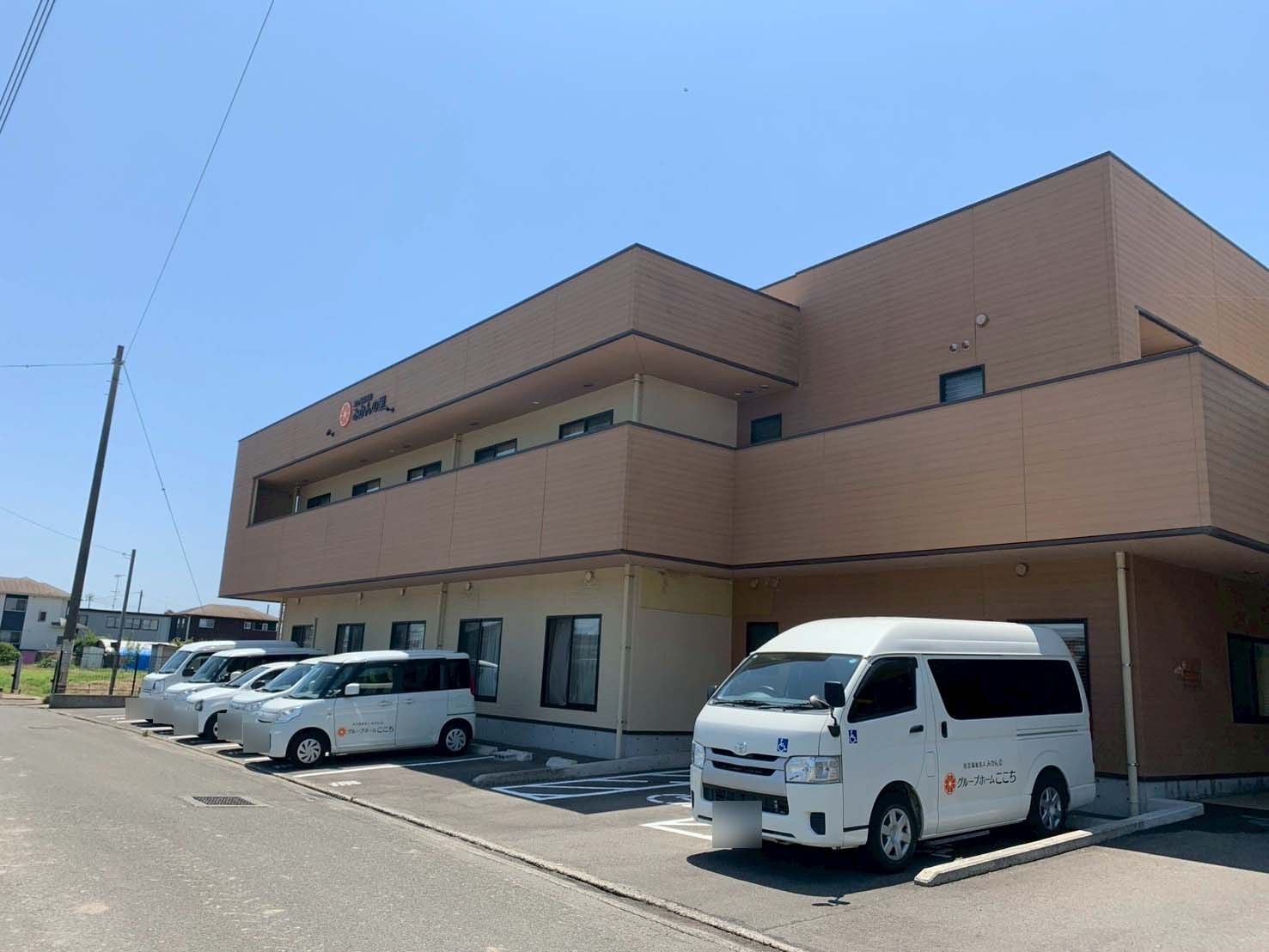 送迎車が並ぶ建物外観