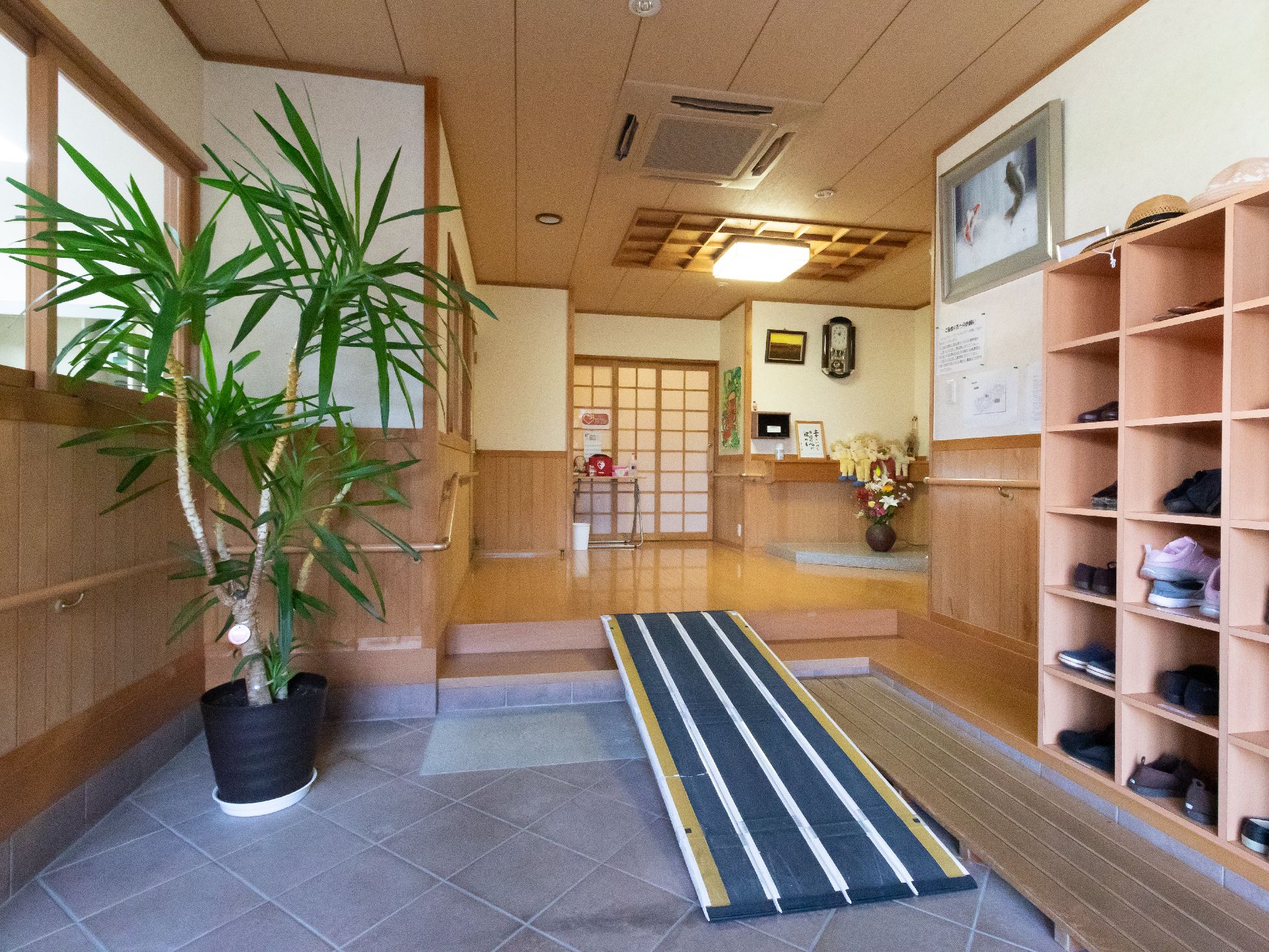 観葉植物があり、階段部分にはスロープが設置されている玄関