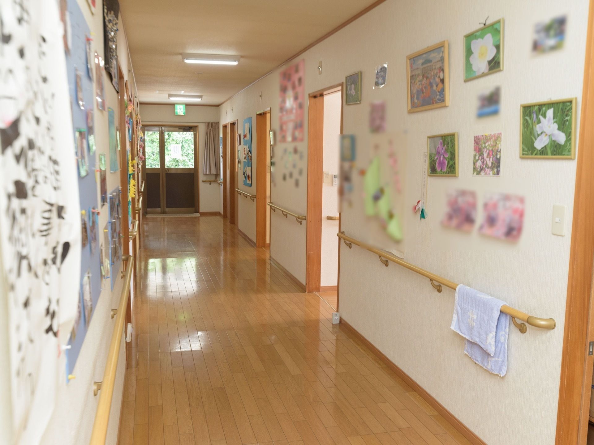 床に段差のない、広い通路。壁には通路に沿って手すりが備え付けられていて、たくさんの写真や絵などが、手すりの上方に掲示されている。