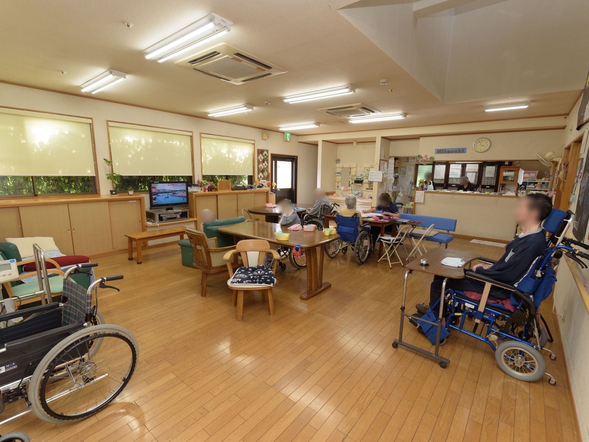 テレビやテーブル、椅子などの設置された共有スペース。部屋の奥にある一画にはキッチンが備え付けられている。