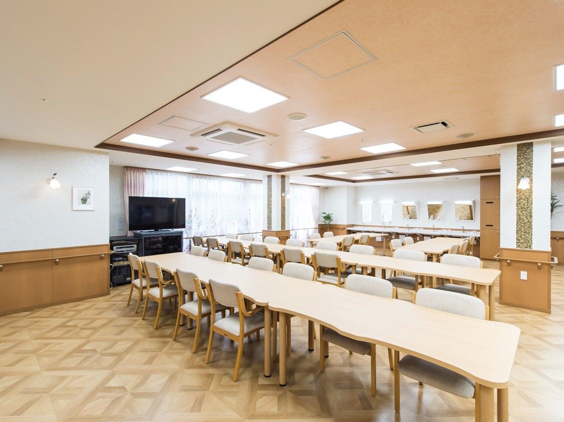 木製のテーブルセットが複数置かれた食堂にはテレビもあり、鏡付きの洗面所が設置されている。