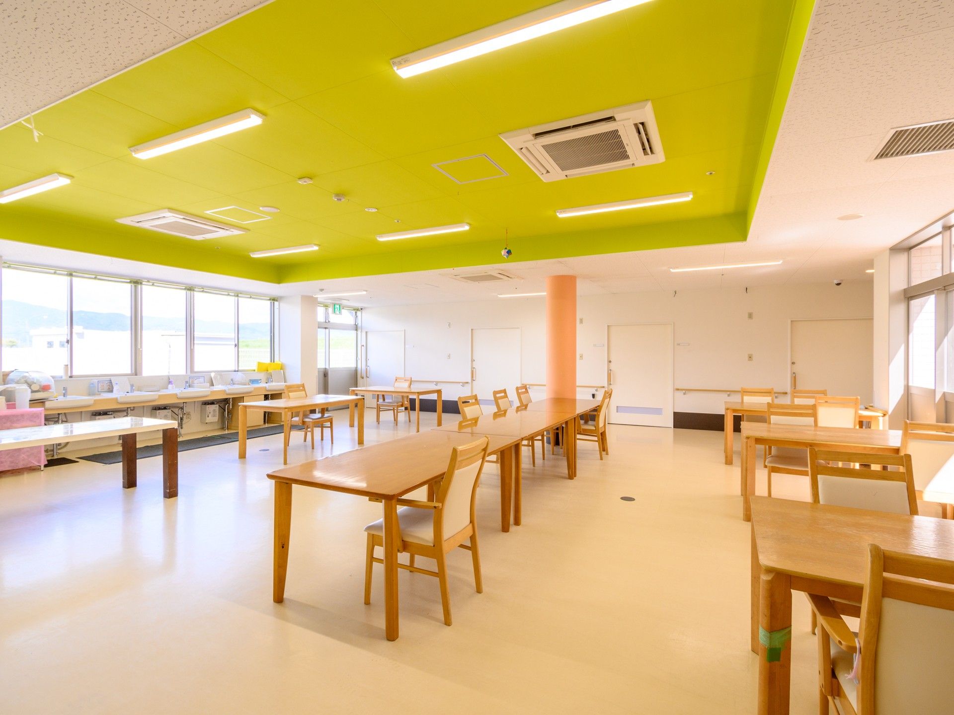 白を基調とした館内。まっすぐな廊下は両サイドに手すりが付き、居室のドアはスライド式で、窓からは陽の光が漏れている。