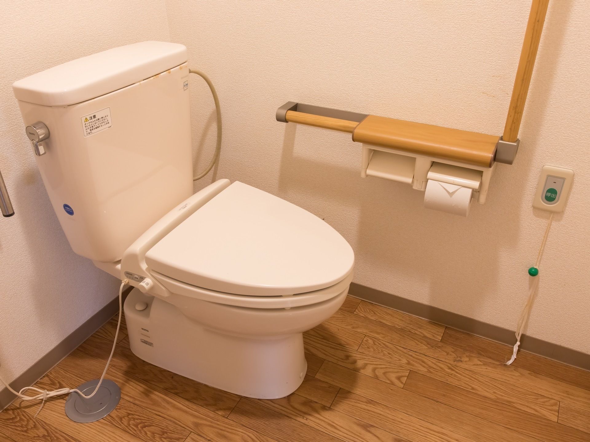 トイレには、カウンター付きのL字型手すりがある。壁の下部あたりに緊急呼び出しブザーが付けられている