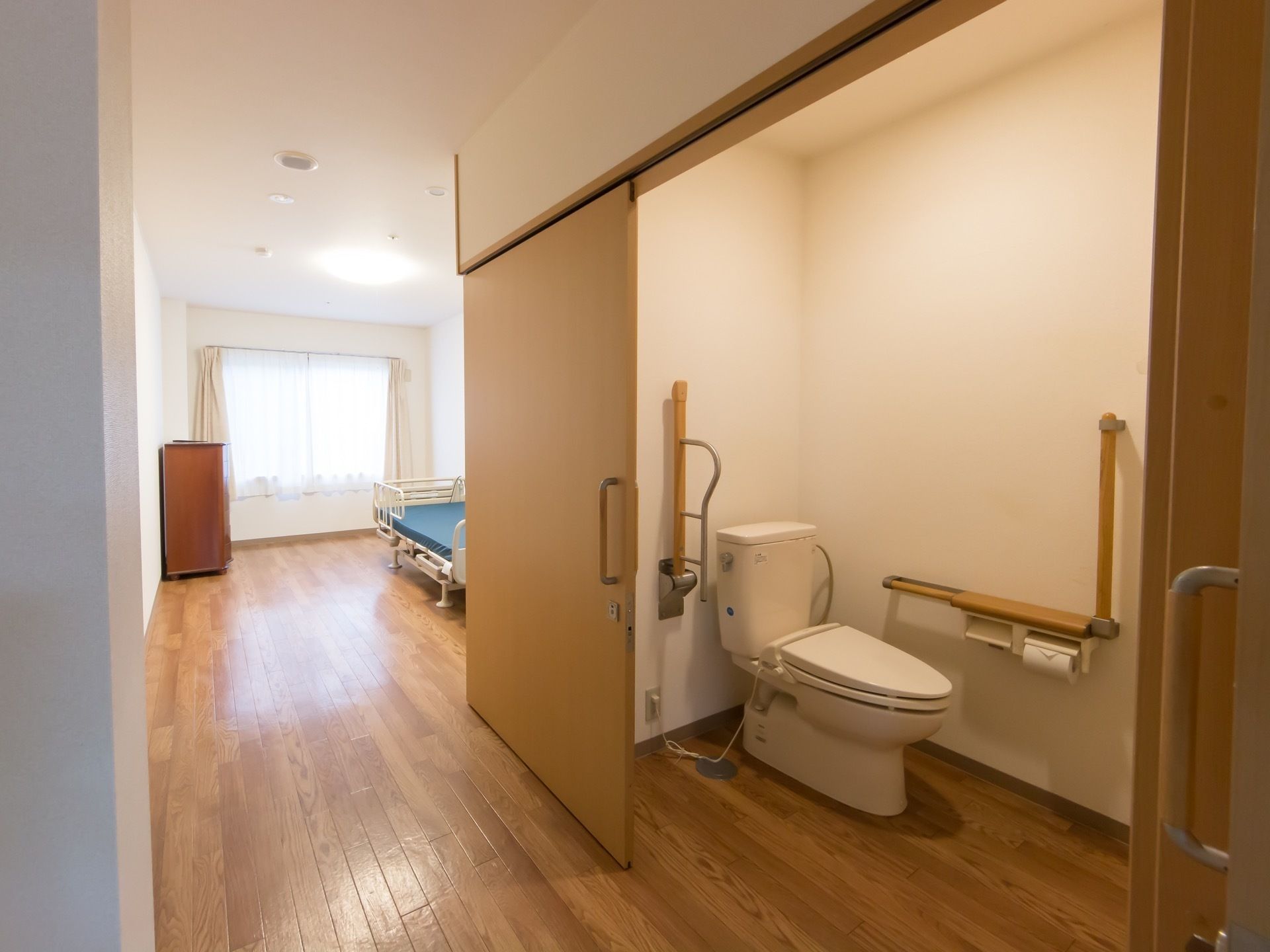 窓のある居室には、トイレが完備されている。段差のないフロアー続きで、スライド式の扉が設置されている。