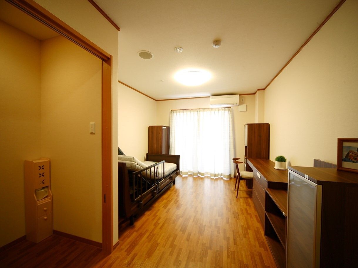エアコンや大きな窓が付いたフローリングの部屋には寝具付きのベッドやタンス、デスクセットなどがあり、日当たりもよい。
