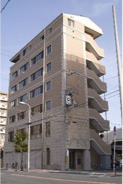対角線上に見た非常階段が造りつけられた７階建ての施設外観