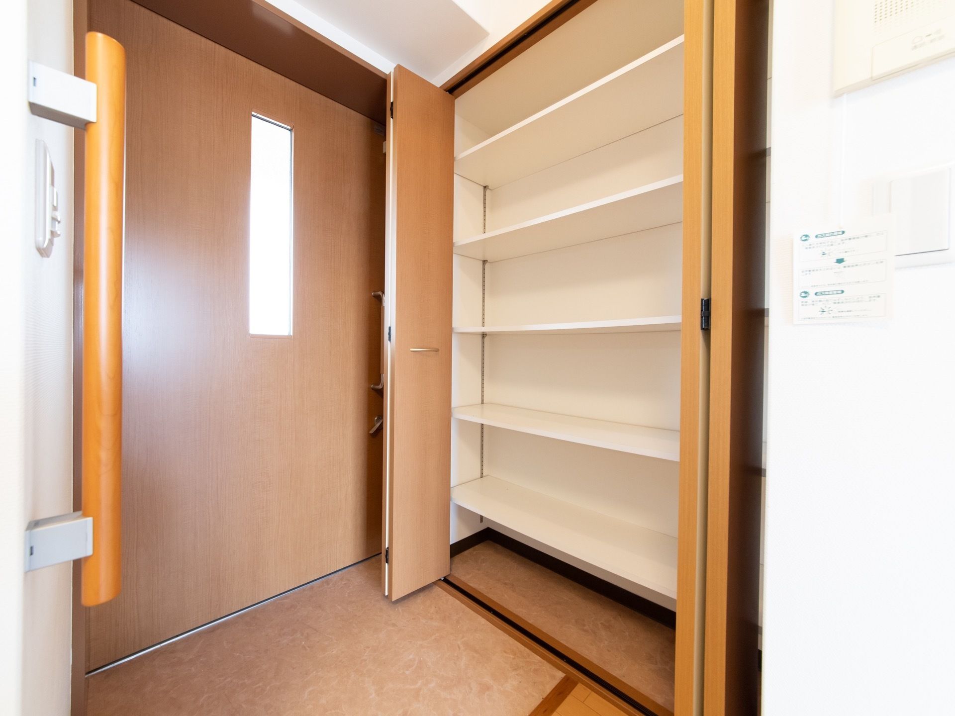 居室のドアはスライド式で開け閉めしやすくなっている。玄関には大きな靴箱が設置されている。中には数段の棚がある。