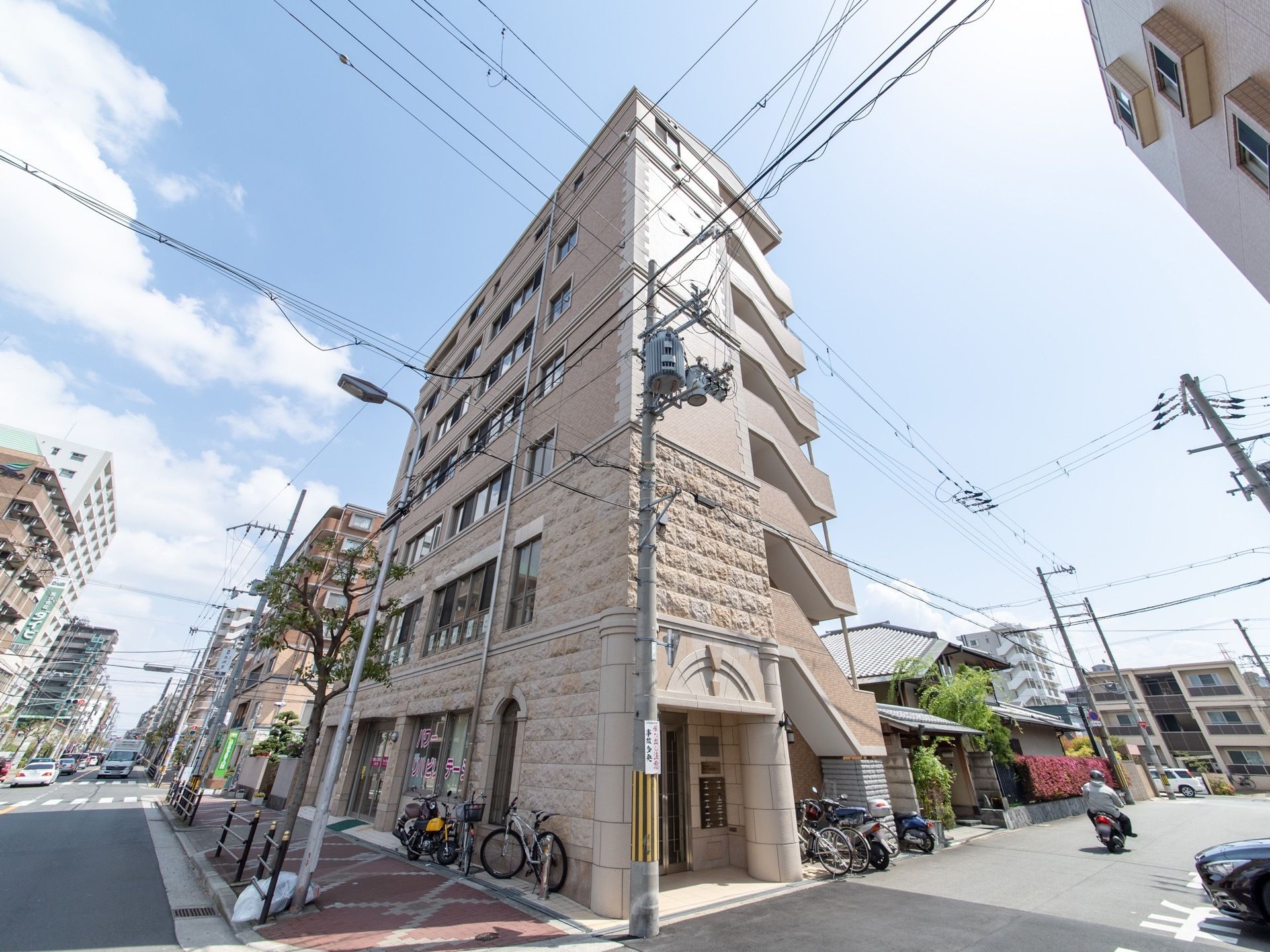 施設は７階建ての高い建物である。マンションのような外観で、外階段がついている。大きな通りの角地に建っているので分かりやすい。