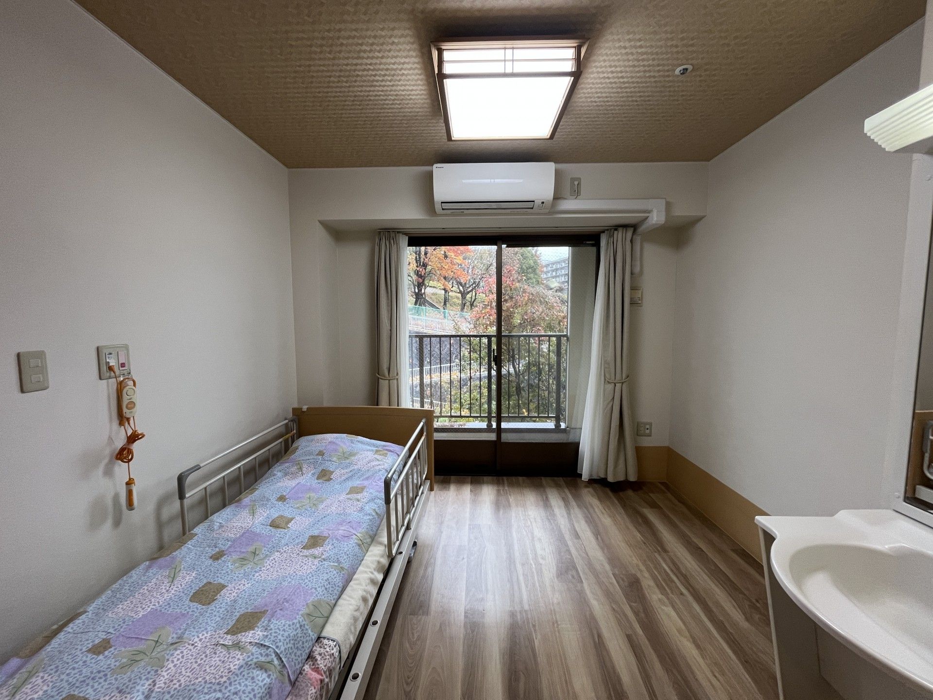 窓際のベッドと洗面台